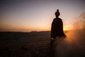 Silhouette of Arab man stands alone in the desert and watching the sunset with clouds of fog. Eastern Fairytale Royalty Free Stock Photo