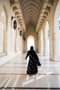 Silhouette of arabian woman in black abaya among beautiful arab architecture
