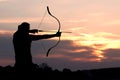 Silhouette archery shoots a bow at a target in sunset sky Royalty Free Stock Photo