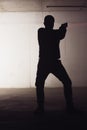 Silhouette of an armed man holding his gun and pointing with his laser beam Royalty Free Stock Photo