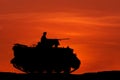 Silhouette armored personnel carrier vehicle on sunset