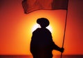 Army soldier with waving flag on sunset background