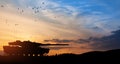 Silhouette of army tank at sunset sky background.