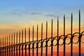Silhouette arrow spiky metal fence against sunset sky background