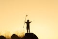 Silhouette of Asian Boy scouts stand on rocky mountains holding flags in their hands to show success on mountain top over sky and Royalty Free Stock Photo