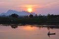 Silhouette of asian fisherman floating in the boat at the sunset