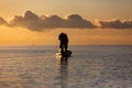 Silhouette of asian Fisherman on a traditional wooden boat during sunrise