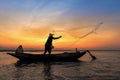 Silhouette of asian fisherman on wooden boat in action Royalty Free Stock Photo