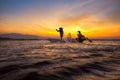 Silhouette asian fisherman on wooden boat Royalty Free Stock Photo