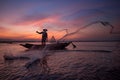 Silhouette of Asian fisherman on wooden boat