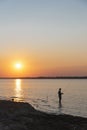 Silhouette of Asian man bank fishing at sunrise on Lavon Lake near Dallas, Texas, USA