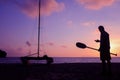 Silhouette asian man with paddle and sailing catamaran on the beach Royalty Free Stock Photo