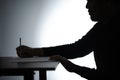 Silhouette asian man writing on table. Beared man writing on Notebook. Freelancer man Blogger writing at Home on desk