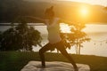 silhouette of asian pregnant woman practicing yoga on green grass in public park. concept of prenatal Royalty Free Stock Photo