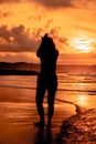 the silhouette of an Asian teenager with a tall body is dancing ballet on the waves on the beach
