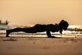 Silhouette of Asian woman practice yoga Plank or Phalakasana Pose on the sand and beach with sunset beautiful sea in Tropical isla Royalty Free Stock Photo