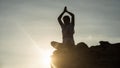 Silhouette Asian woman sit and perform lotus hands yoga meditation pose on mountain cliff peak Royalty Free Stock Photo