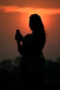 Silhouette asian woman touching smartphone at Sunset time Royalty Free Stock Photo