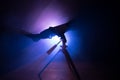 Silhouette of a astronomy telescope on dark foggy backlight