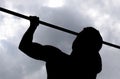 Silhouette of an athlete on a bar. The man pulls himself up on the bar. Playing sports in the fresh air.