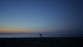 Silhouette athlete girl exercising on seacoast at dusk. Woman practicing yoga. Royalty Free Stock Photo