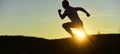 Silhouette of athlete running on sunset background, copy space. Royalty Free Stock Photo