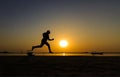 Silhouette Of Athletic Running On The Sunrise Beach