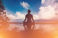 Silhouette Athletic woman practice yoga lotus pose to meditation summer vacation on pier with sunset sea beach