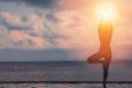 silhouette Athletic woman practice yoga lotus pose to meditation summer vacation on pier with sunset sea beach