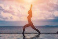 silhouette Athletic woman practice yoga Warrior one pose to meditation summer vacation on pier with sunset sea beach Royalty Free Stock Photo