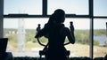 Silhouette of attractive young woman at the gym exercising on the xtrainer machine