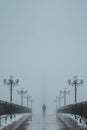 silhouette back lonely man maniac walks on foggy bridge with lanterns in winter with snow and fog mist Royalty Free Stock Photo