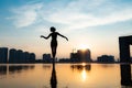 Silhouette of ballerina performing on cityscape and dramatic sunset background. Concept of individuality, creativity and