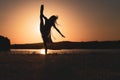 Silhouette of a ballerina posing by a lake - concept: freedom, elegance