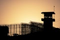 Silhouette of barbed wires and watchtower of prison