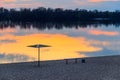 Silhouette of beach sunshade on beach of the Dnieper river at sunset