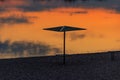 Silhouette of beach sunshade on beach of the Dnieper river at sunset