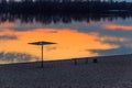 Silhouette of beach sunshade on beach of the Dnieper river at sunset