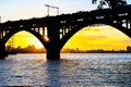 Silhouette of a beautiful arched railway bridge and wagons on the Dnieper river at sunset. Dnipropetrovsk Royalty Free Stock Photo