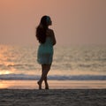 Silhouette of a beautiful girl standing on the beach at sunset Royalty Free Stock Photo