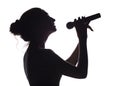 Silhouette of beautiful girl singing into microphone, profile of young woman face performing lyric song on white isolated Royalty Free Stock Photo