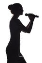 Silhouette of girl singing into microphone, profile of young woman face performing lyric song on white isolated background Royalty Free Stock Photo