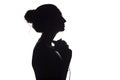 Silhouette of a girl with with headphones around neck, a young woman listening to music on a white isolated background, concept of