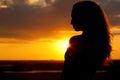 Silhouette of a beautiful girl at sunset, face profile of young woman enjoying nature