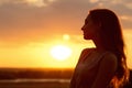 Silhouette of a beautiful girl at sunset in a field, face profile of young woman enjoying nature Royalty Free Stock Photo