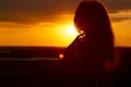 Silhouette of a beautiful girl at sunset in a field, face profile of young woman enjoying nature Royalty Free Stock Photo
