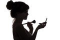 Silhouette of girl doing make-up, profile of female face on white isolated background, concept of fashion and beauty