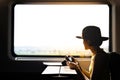 A silhouette of beautiful hipster asian woman traveling on the train. Sitting