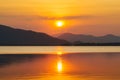 Silhouette, beautiful landscape with sunset at coast of the lake in summer. Nature twilight time, reflection, orange sky and