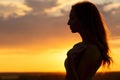 Silhouette of a beautiful romantic girl at sunset , face profile of young woman with long hair in hot weather Royalty Free Stock Photo